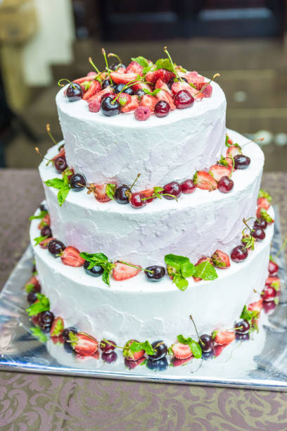 istock White wedding cake decorated by flowers fruits 1438356934