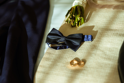 The groom's fees, a stylish man adjusts his jacket and watch rings bouqet