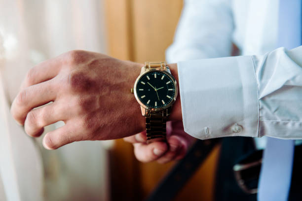 istock man putting clock on hand,groom getting ready in the morning 1438357040