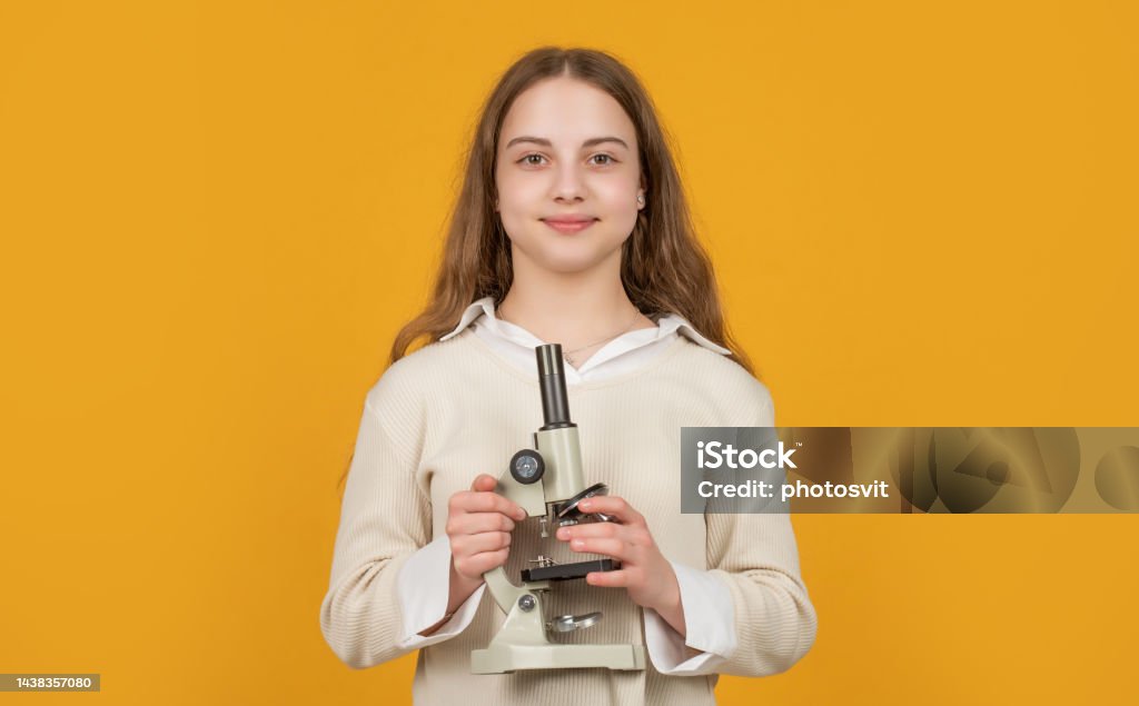 glad kid with microscope on yellow background glad kid with microscope on yellow background. Back to School Stock Photo