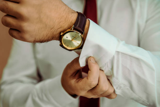 istock man putting clock on hand,groom getting ready in the morning 1438357755