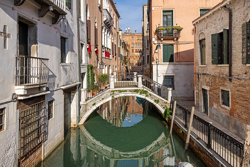 Venice, Italy - October 9th 2022:  Arch bridge made of marble over a narrow canal in the center of the old and famous Italian city Venice