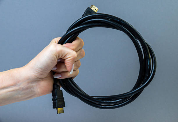 istock female hand holding hdmi cable on gray background isolated 1438361008