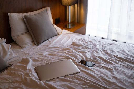 Portable devices on bed, laptop computer and mobile phone, concept of blogger and working at home, digital lifestyle