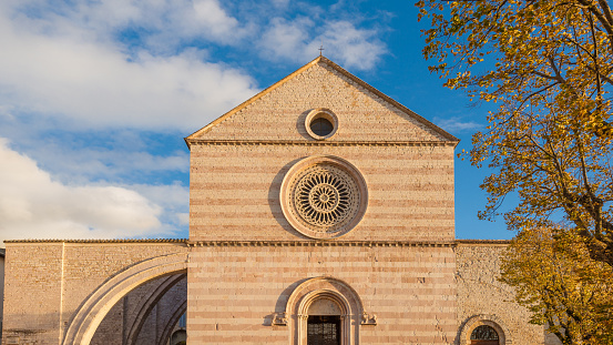Basilica of Saint Clare in Assisi with autumn leaves