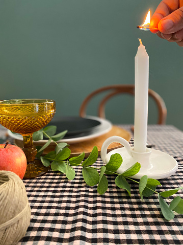 Hand lighting a candle on the decorated table