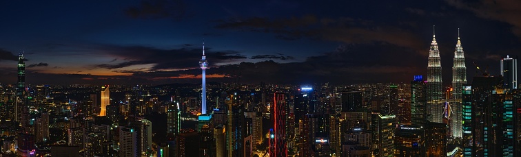 A panoramic shot of the urban city of Kuala Lumpur with skyscrapers at night