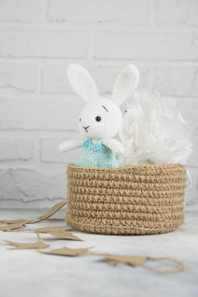 istock Knitting white toy hare is in knitting basket in light background. 1438368838