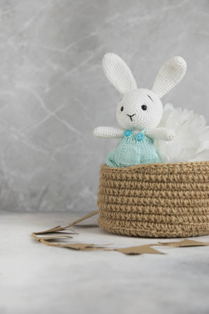 istock Knitting white toy hare is in knitting basket in light background. 1438368844