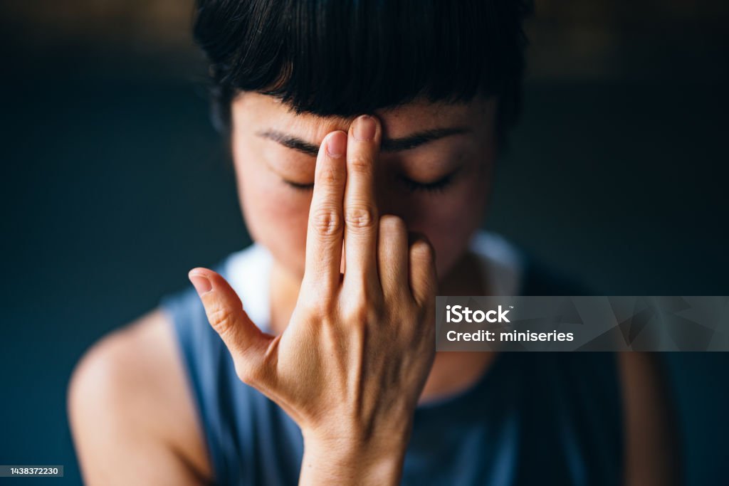Beautiful Woman Meditating Close up photo of happy Asian woman in sportswear doing breathing exercise in the yoga studio. Meditating Stock Photo