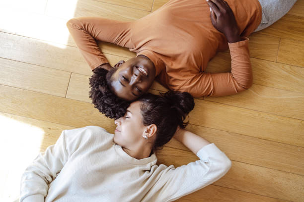 istock Two young women lying head to head on the floor 1438372582