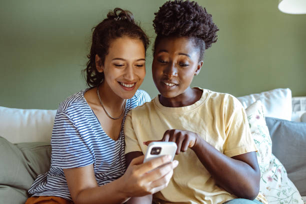 istock Two young women use smart phones at home 1438372686