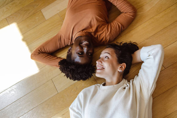 istock Two young women lying head to head on the floor 1438373041