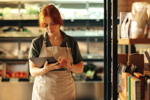 istock Shop owner using a digital tablet in her grocery store 1438376521