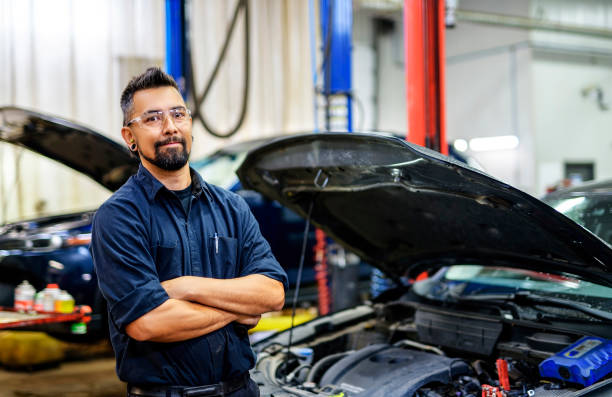 istock Handsome mechanic job in uniform working on car 1438376535