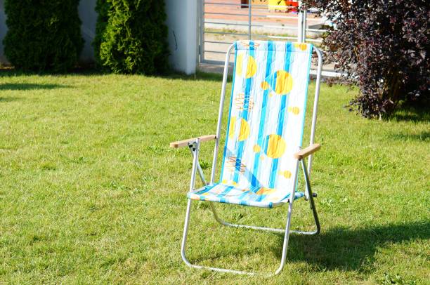 istock Blue and white striped sun chair on the green grass 1438377714