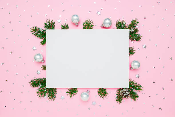 Christmas, New Year holiday card with copy space for text. Blank white paper in frame of natural fir tree branches and silver decorations on pastel pink flat lay background. Christmas, New Year holiday card with copy space for text. Blank white paper in frame of natural fir tree branches and silver decorations on pastel pink flat lay background blank christmas card stock pictures, royalty-free photos & images