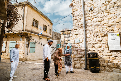 Peki'in, Israel- October 22, 2022. Jeweish family in Old  Neighborhood of Druze village of Peki'in, Israel. Old traditional  northern village Peki'in is a small village in the upper Galilee, half-way between Akko and Safed. Most of the village is inhabited by Druze, Peki'in is known for its small Jewish community and synagogue.