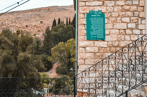 Rosh Pinah, Israel- October 21, 2022. Street view of synagogue in old neighborhood in Rosh Pinah, Israel. Old traditional  northern village where aged olive trees and quaint historic homes are surrounded by fields.