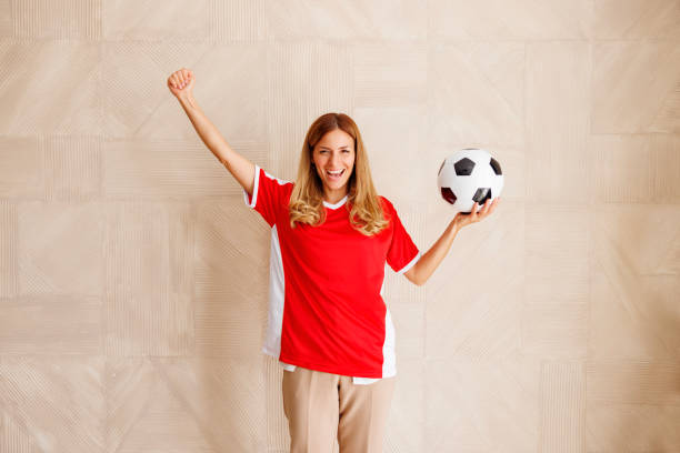 istock Woman cheering for her team while watching football 1438380627