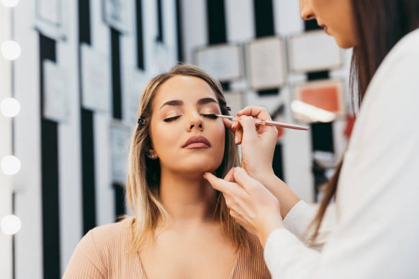 maquilleuse professionnelle au travail - make up foundation cosmetics face powder photos et images de collection