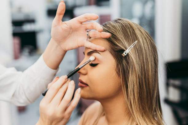 Professional makeup artist at work Professional makeup artist doing professional make up of beautiful young woman. makeup artist stock pictures, royalty-free photos & images