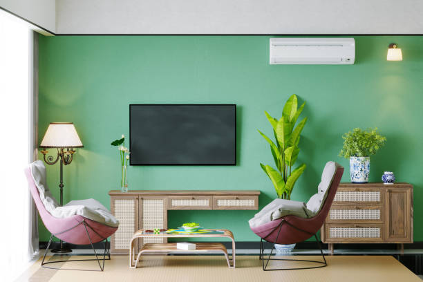 stilvolles wohnzimmer interieur mit sessel, klimaanlage, tv-schrank und grüner wand - air conditioner window heat hot day stock-fotos und bilder