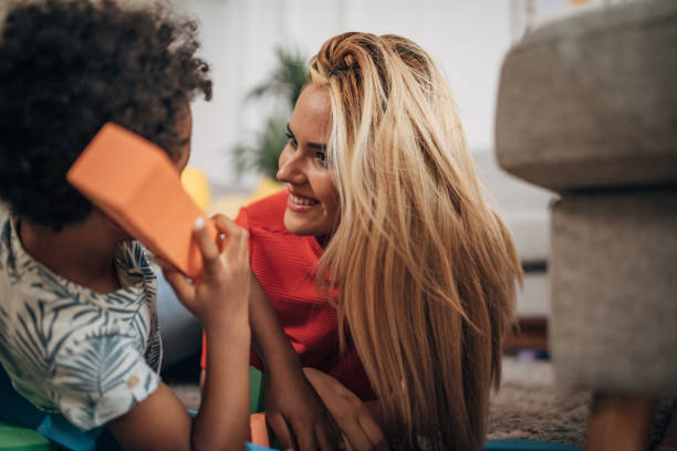 istock Mother playing with son in living room 1438384319