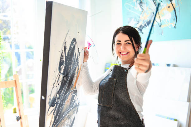 istock Portrait of a woman artist working on several art projects on her studio 1438385368