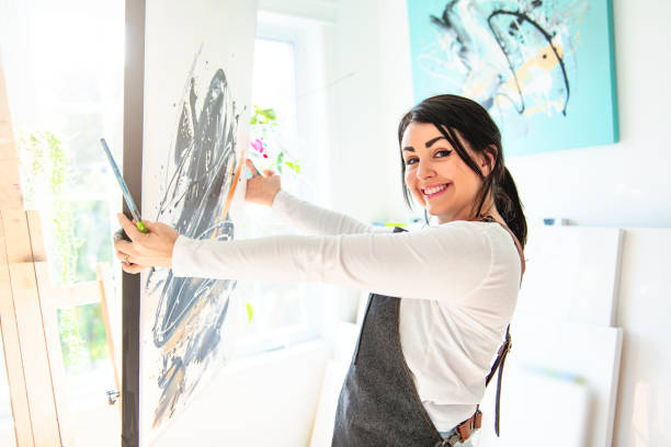 istock Portrait of a woman artist working on several art projects on her studio 1438385373