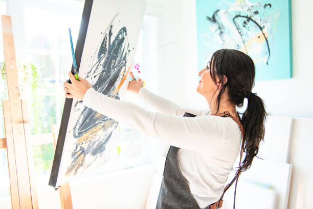 istock Portrait of a woman artist working on several art projects on her studio 1438385393