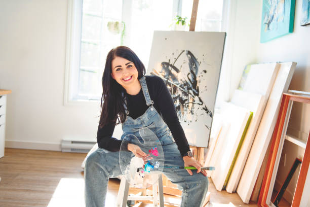 istock Portrait of a woman artist working on several art projects on her studio 1438385633