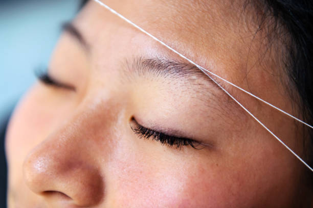 istock eyebrow waxing with threading on a young woman 1438385770