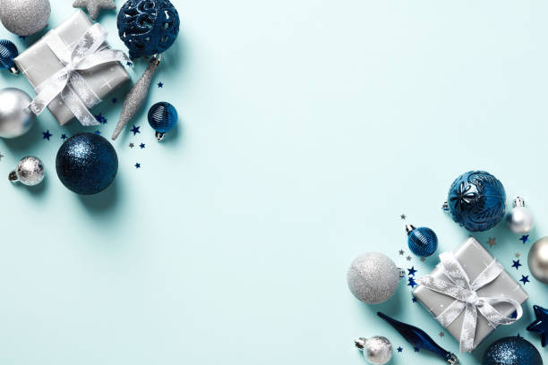 istock Christmas card with blue and silver ornaments on light blue background. Flat lay, top view. 1438388382
