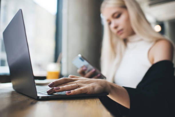 serious frau mit laptop und smartphone im café - prepossessing stock-fotos und bilder