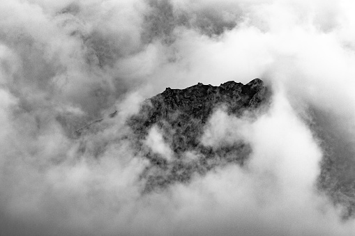 Rock formation texture and pattern surrounded in cloud of mist. Black and white background