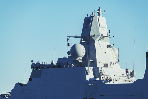 Navy frigate enters a harbour after offshore training exercises.