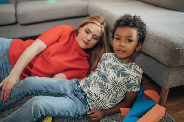 istock Mother playing with son in living room 1438395387