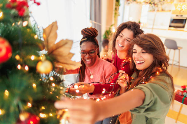 istock Girl friends decorating Christmas tree 1438395653