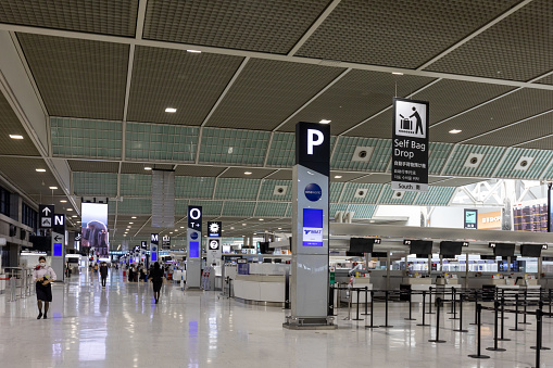 Narita, Japan - September 9, 2022 : People at a check-in area in a departure hall at Narita International Airport in Narita, Chiba Prefecture, Japan. Narita International Airport is an international airport serving the Greater Tokyo Area.