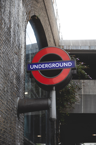 London, UK - May 09, 2021: Station name and way out sign on the platform of Swiss Cottage station of London Underground, the oldest underground railway in the world, motion blur and selective focus.