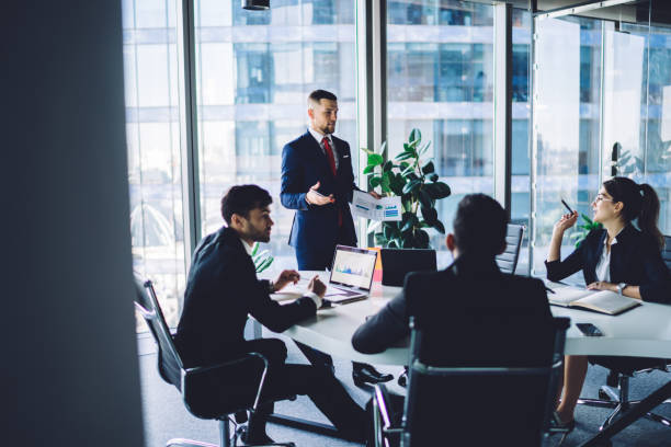 istock Group of colleagues discussing business ideas at conference in modern workspace 1438401087