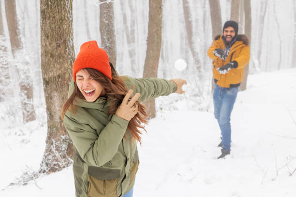 istock Couple having a snowball fight while on winter vacation 1438402364