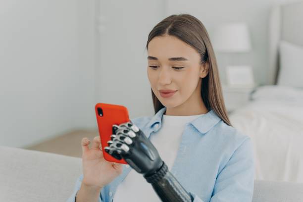 istock Happy disabled young girl with bionic arm prosthesis holding smartphone, shopping in online store 1438404270