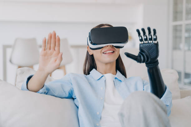 istock Smiling young girl wearing virtual reality glasses learning to use high tech bionic prosthetic arm 1438404309