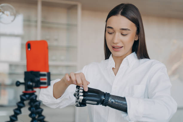 istock Disabled young girl blogger shooting video on smartphone on tripod, speaking about bionic prosthesis 1438404328