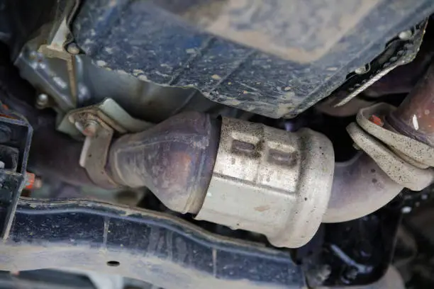 Photo of Closeup catalytic converter of a modern car bottom view. Shallow focus.