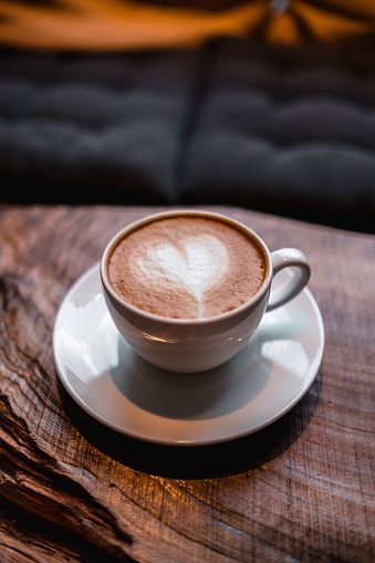 A cup of cappuccino with a heart on it on the table