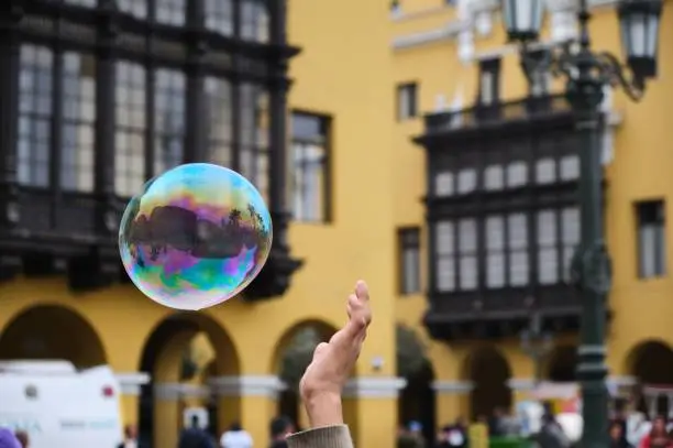 A shallow focus of a hand touching soapbubble