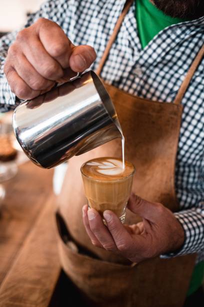 istock Vertical shot man pouring milk into cappuccino 1438409862